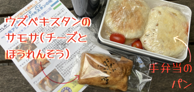 手弁当のパン(プラスチックのお弁当箱ぎゅうぎゅうに詰められたラップがけのマフィン二つと、すきまにミニトマト二つ)と、ウズベキスタンのサモサ(チーズとほうれんそう)。後者はデニッシュっぽい層のある生地で包まれキツネ色に焼かれた、スマートフォンより一回り小さな四角いパン(パイ?)という感じ。黒ゴマがトッピングされている。