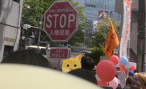 デモ出発の様子。皆おのおの二個や三個の風船を、少し先の人が交通標識を模した「(改悪入管法施行反対)STOP 人権侵害(人にやさしく)」のプラカを掲げている