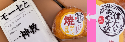 ベンチの上に置かれたフロイト『モーセと一神教』文庫と「偉大なおむすびWチーズ醤油」・「偉大なおむすび」ロゴのアップ。