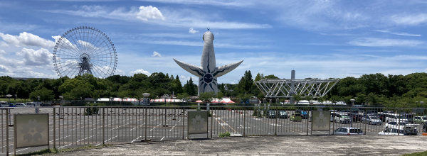 昨年7月の万博公園・後ろから見た太陽の塔と雲を引く青空。