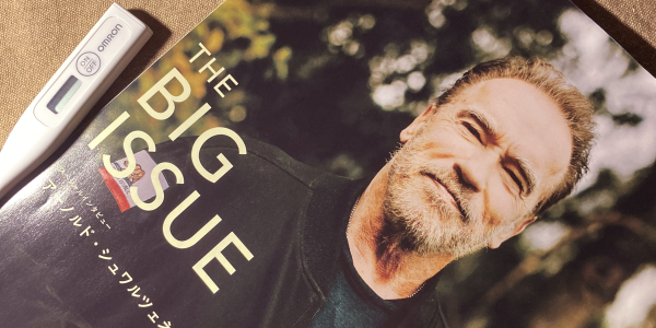 体温計と、シュワルツェネッガーを表紙に配したビッグイシュー最新号。